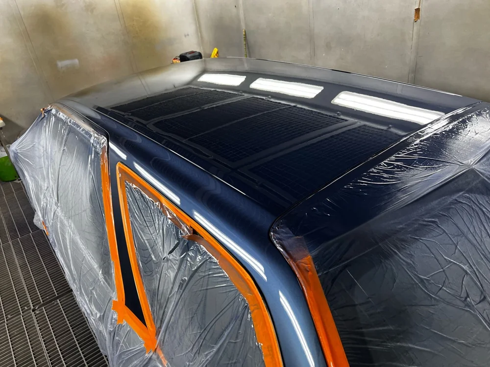 Refinished blue vehicle roof in the workshop spray booth
